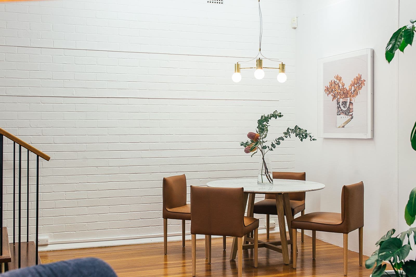 Painted brick interior with brass pendant lighting, in keeping with Alexandria's historic housing character
