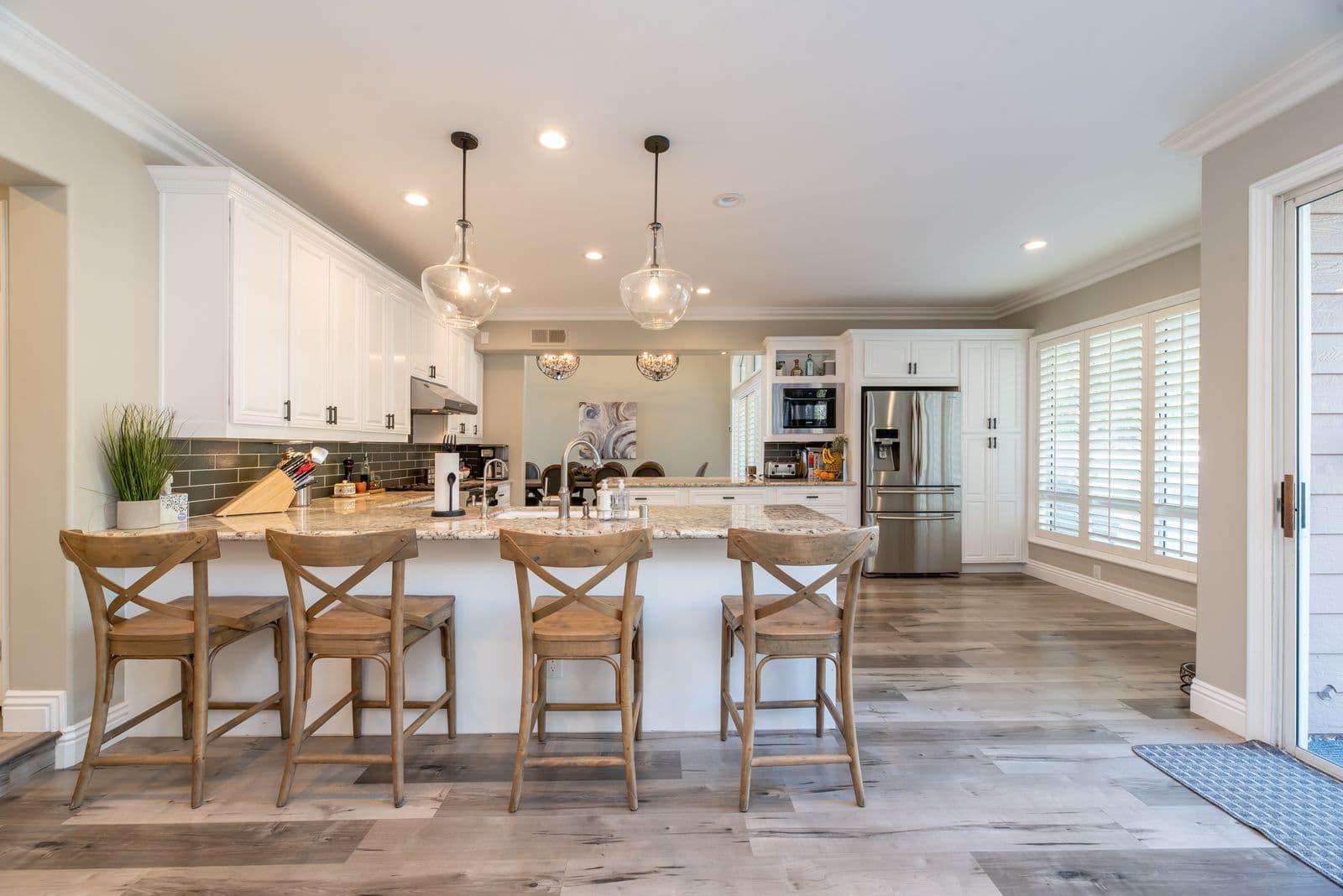 Granite kitchen countertops on a peninsula with seating in a remodeled transitional kitchen