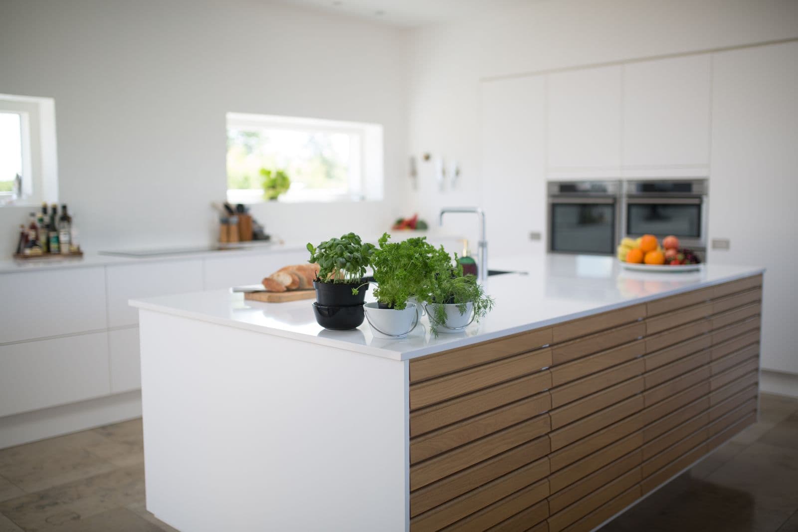 Minimal kitchen design concept pairing white cabinetry with a natural oak island